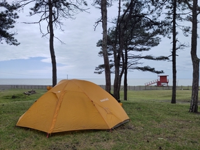 Notre tente face à la mer sous les pins. Vue sur la petite cabane rouge et vide des surveillants de plage.