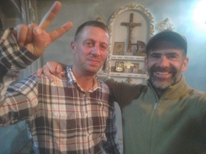 Selfie de mon ami megrelien et de moi-même devant le petit oratoire de la maison (croix et icônes)