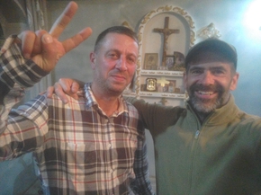 Selfie de mon ami megrelien et de moi-même devant le petit oratoire de la maison (croix et icônes)