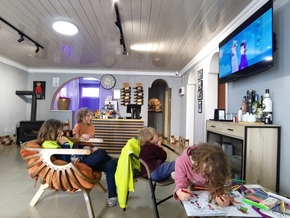 Les enfants regardent un dessin animé ou dessinent dans la salle du restaurant
