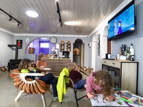 Les enfants regardent un dessin animé ou dessinent dans la salle du restaurant
